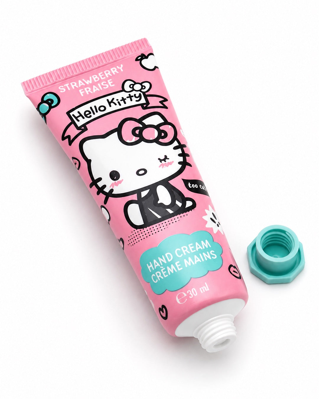 Tube de crème pour les mains Hello Kitty à la fraise posé à plat avec son bouchon hexagonal vert dévissé, montrant l’embout distributeur blanc.