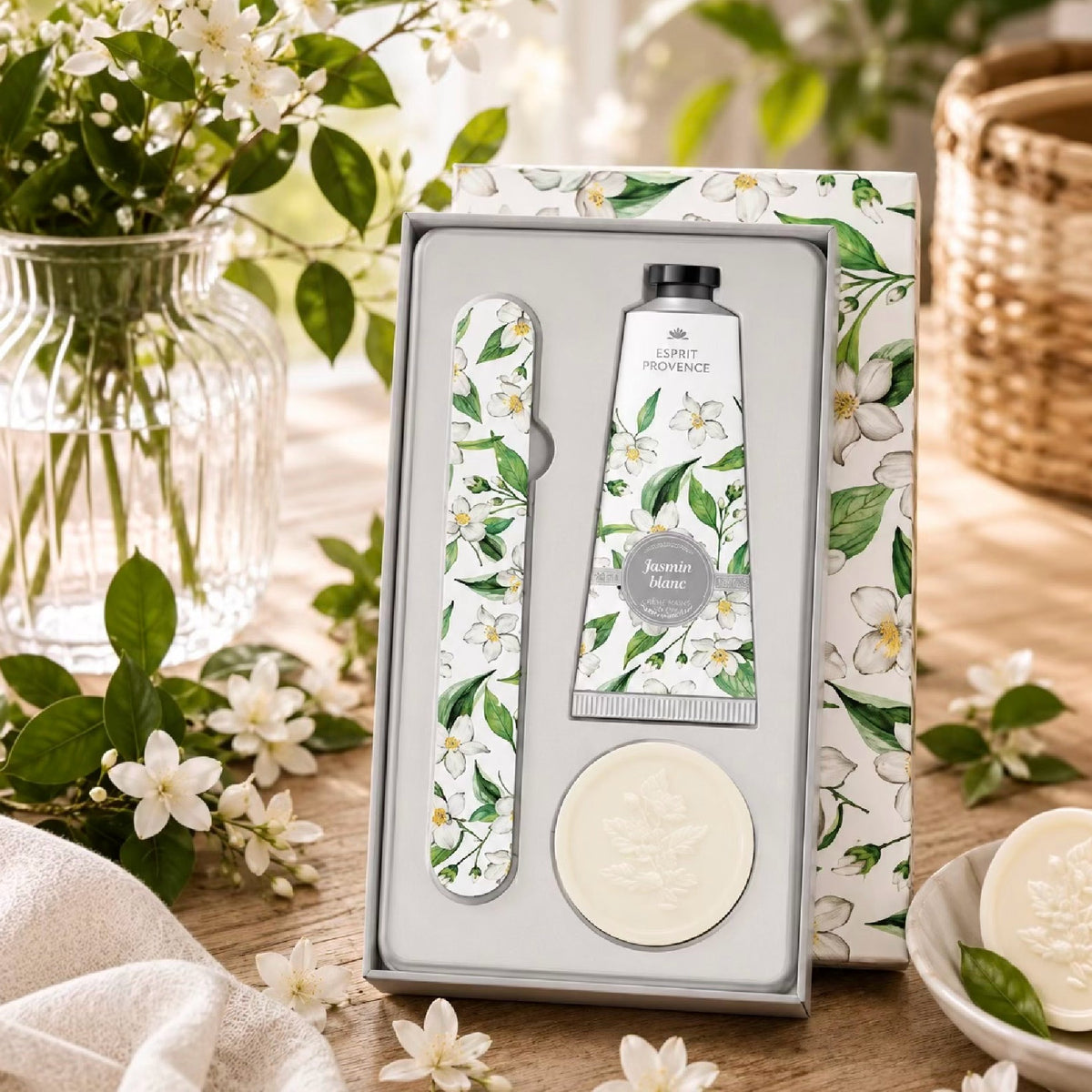 Coffret de soin pour les mains Esprit Provence à la vanille intense comprenant une crème pour les mains, une lime à ongles fleurie et un petit savon rond gravé d'une fleur, présenté dans une boîte assortie aux motifs floraux.