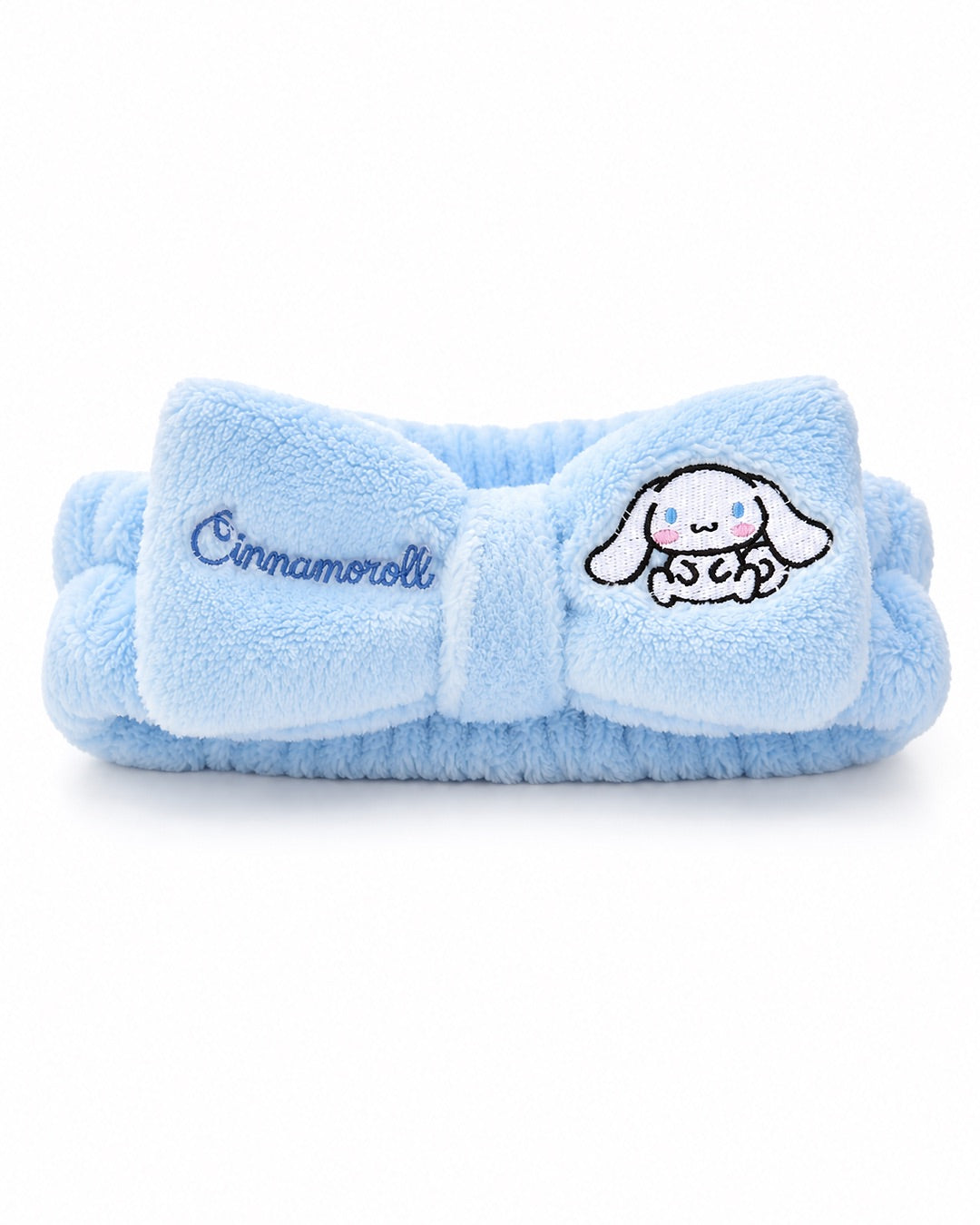 Bandeau de tête élastique en peluche bleu ciel avec un grand nœud central brodé du nom et du personnage Cinnamoroll de Sanrio.