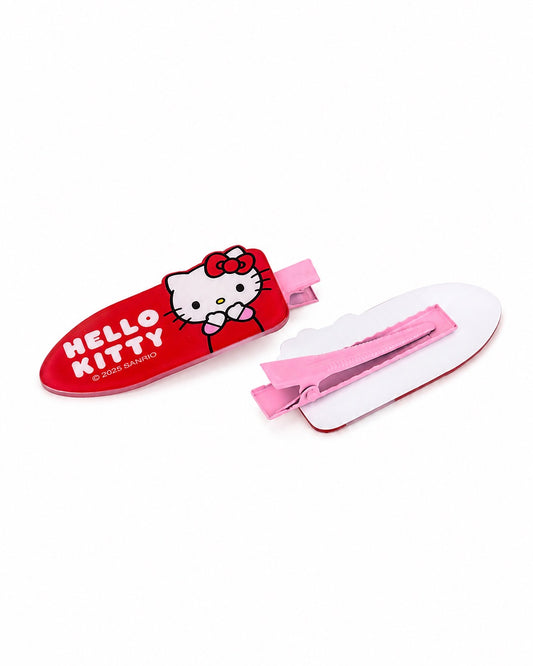 Vue rapprochée de deux barrettes Hello Kitty rouges en acrylique, montrant la face avant décorée et la pince crocodile rose à l’arrière.