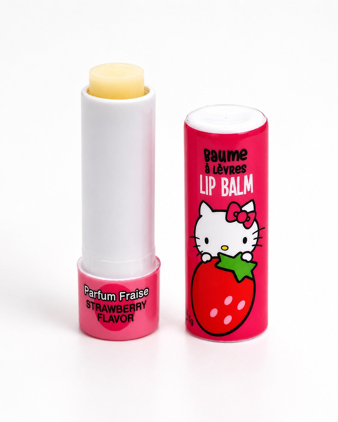 Tube de baume à lèvres Hello Kitty ouvert révélant le stick de soin hydratant translucide, avec son capuchon rose posé juste à côté.