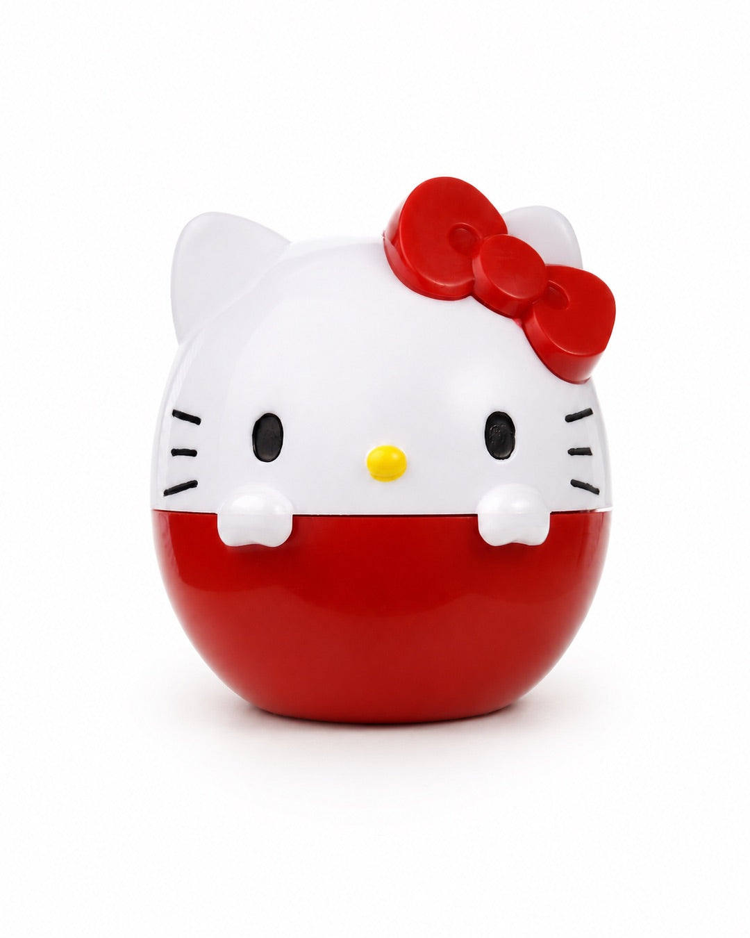 Vue de face d’un baume à lèvres sphérique rouge en forme de figurine 3D d’Hello Kitty avec son nœud rouge en relief.