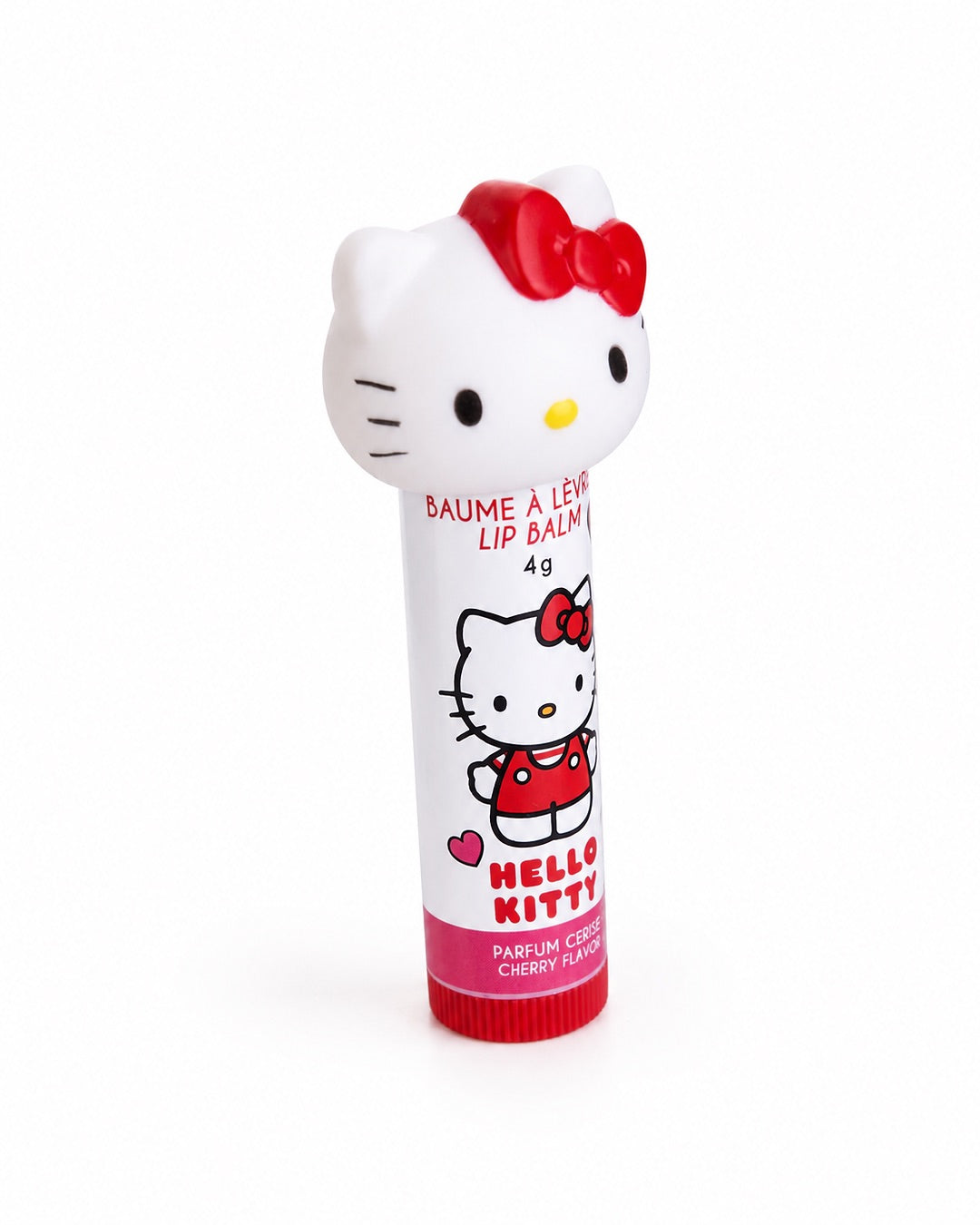 Vue inclinée de trois quarts du tube blanc de baume à lèvres Hello Kitty à la cerise mettant en valeur le bouchon en relief avec son nœud rouge.