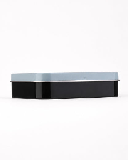 Vue de profil de la boîte métallique fermée mettant en valeur son design compact bicolore bleu et noir.