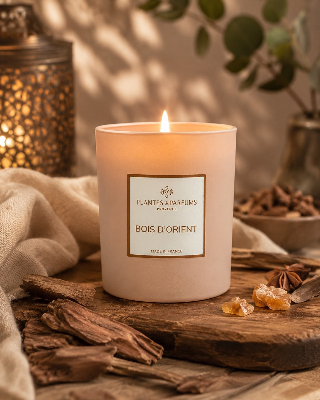 Bougie parfumée 180 g, fragrance Bois d’Orient de Plantes & Parfums à la cire de soja dans un contenant en verre beige mat, ambiance boisée.
