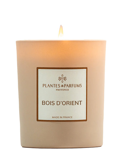Bougie parfumée 180 g, fragrance Bois d’Orient de Plantes & Parfums à la cire de soja dans un contenant en verre beige mat.