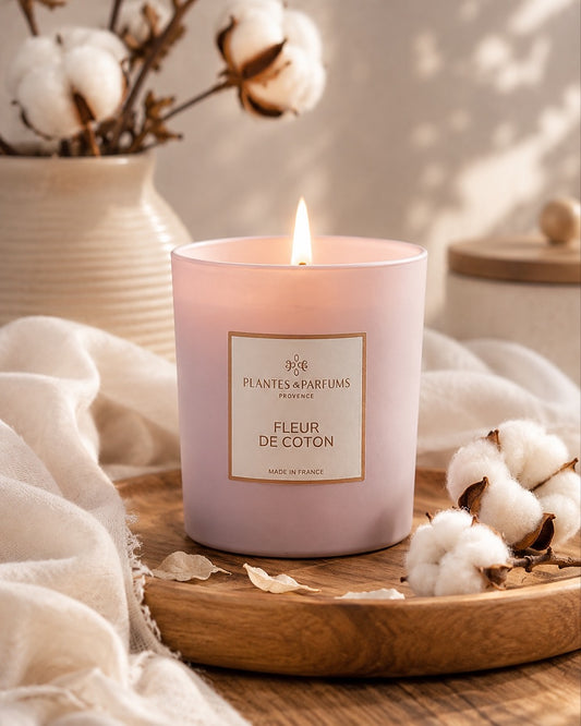 Bougie parfumée 180 g, fragrance Fleur de coton de Plantes & Parfums à la cire de soja dans un contenant en verre rose mat, ambiance florale.
