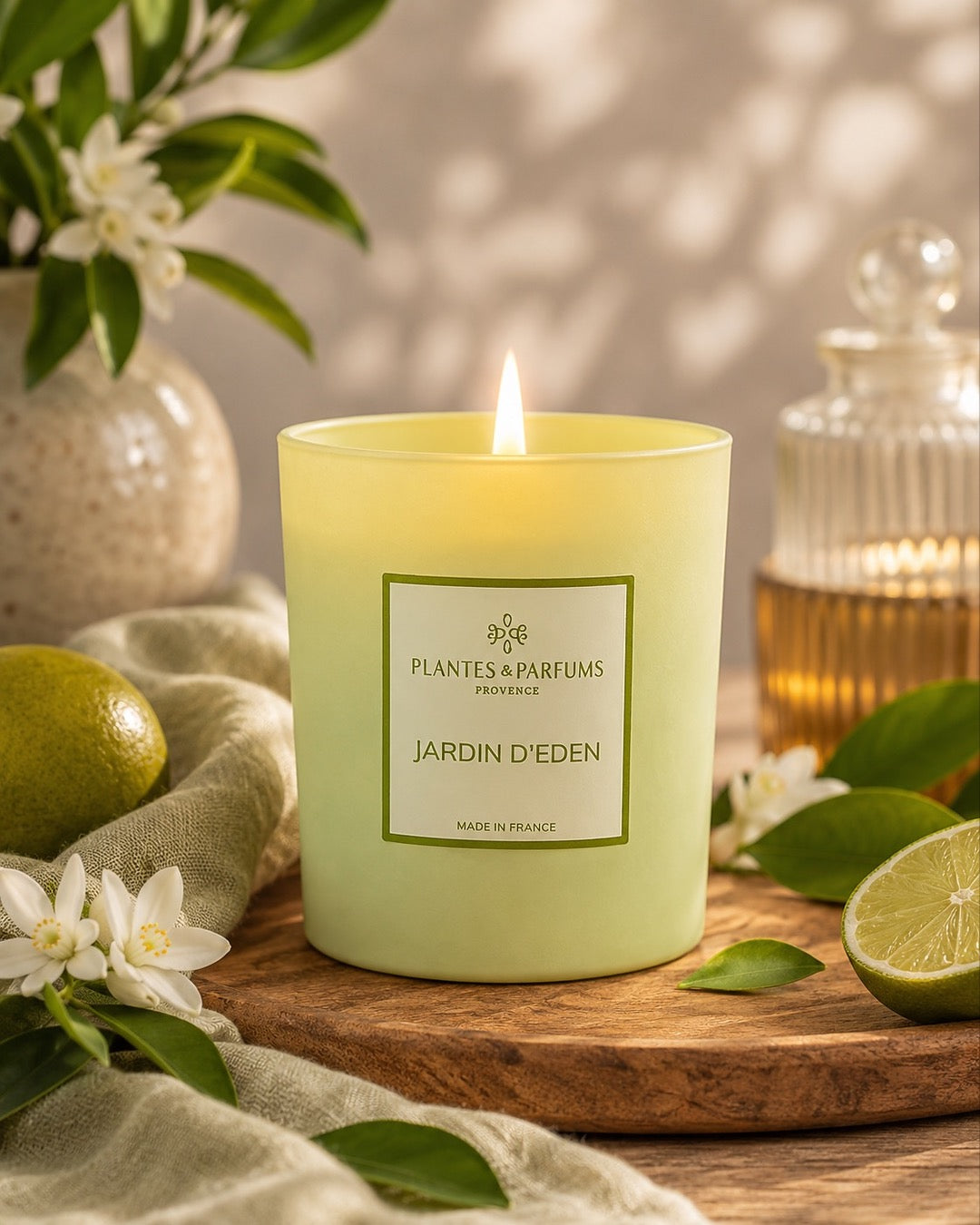 Bougie parfumée 180 g, fragrance Jardin d’Éden de Plantes & Parfums à la cire de soja dans un contenant en verre vert mat, ambiance frais.
