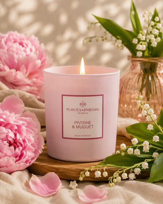 Bougie parfumée 180 g, fragrance Pivoine & Muguet de Plantes & Parfums à la cire de soja dans un contenant en verre rose mat, ambiance florale.