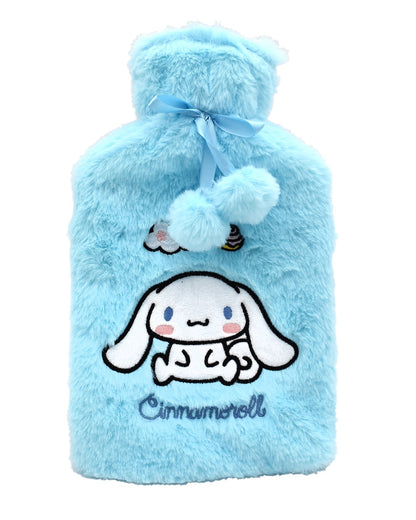 Bouillotte verticale en fausse fourrure bleu ciel affichant le petit chien blanc un ruban de satin bleu et deux pompons duveteux suspendus au col.