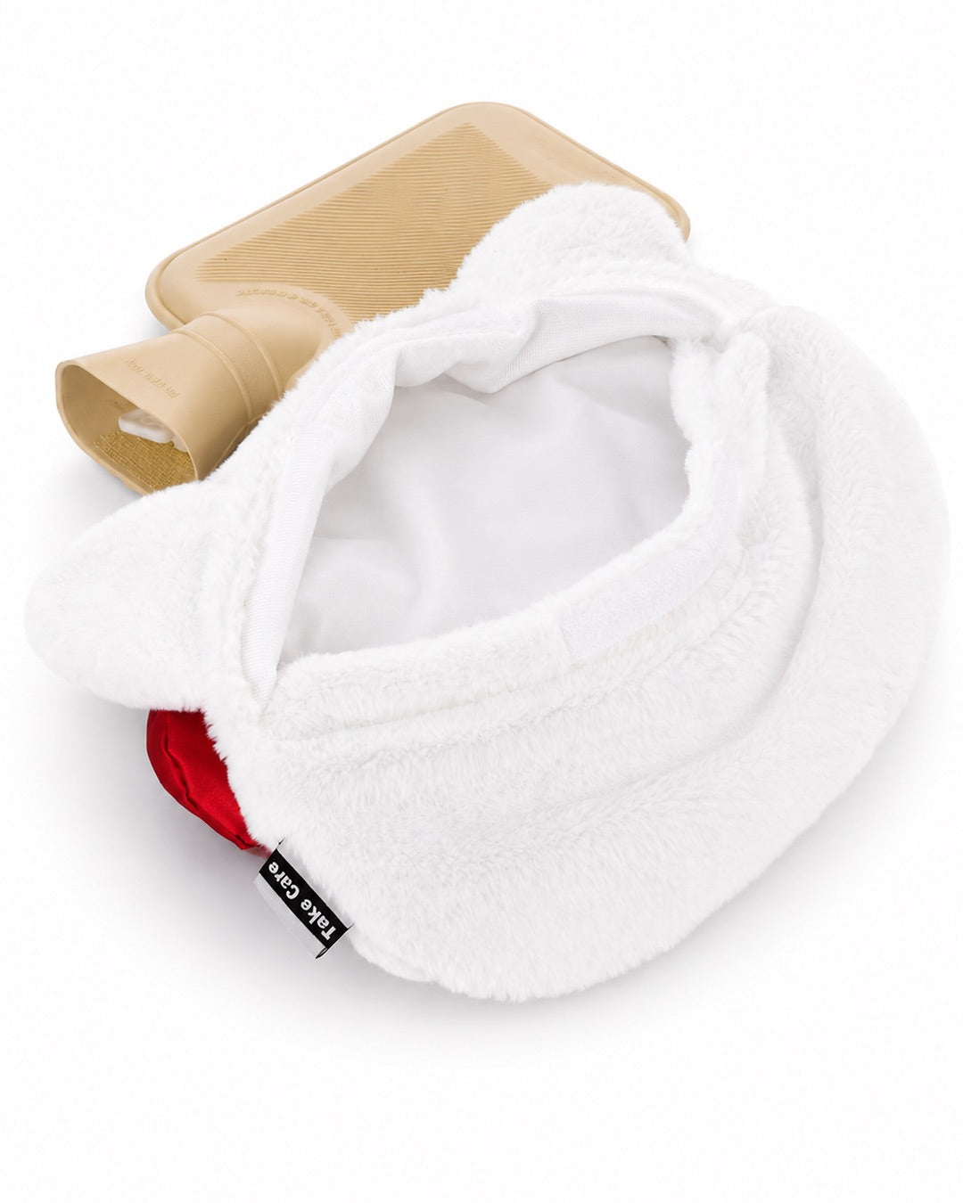 Vue arrière de la peluche Hello Kitty montrant la poche de bouillotte en caoutchouc beige en train d’être insérée dans la fente de la pochette.