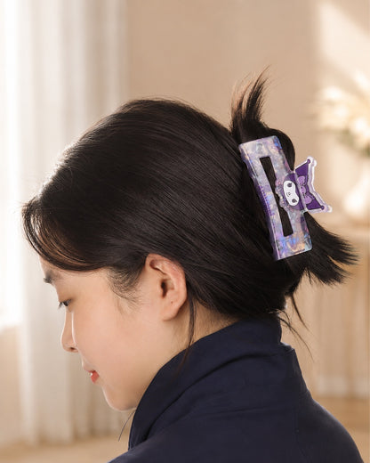 Profil d'une femme portant la grande pince à cheveux rectangulaire mauve Kuromi Sanrio pour attacher ses cheveux.