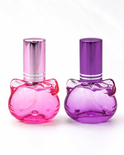 Duo de flacons d'eau de toilette rechargeables en verre en forme de tête d’Hello Kitty avec bouchons métallisés, l’un rose bonbon et l’autre violet améthyste, disponibles dans notre boutique en ligne au Québec.