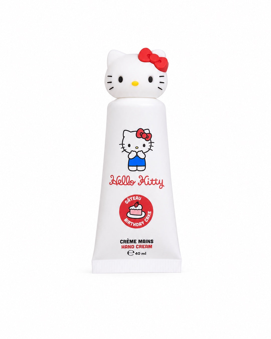 Vue de face d’un tube blanc de crème pour les mains inclus dans le coffret Hello Kitty de 40 ml au parfum de gâteau d’anniversaire, surmonté d’un bouchon 3D en forme de tête de la mascotte.