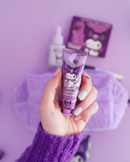 Modèle
Une main avec une manucure pastel tenant le tube de crème pour les mains et les ongles Kuromi Sanrio devant une trousse violette et les items de la collection Kuromi en arrière plan.