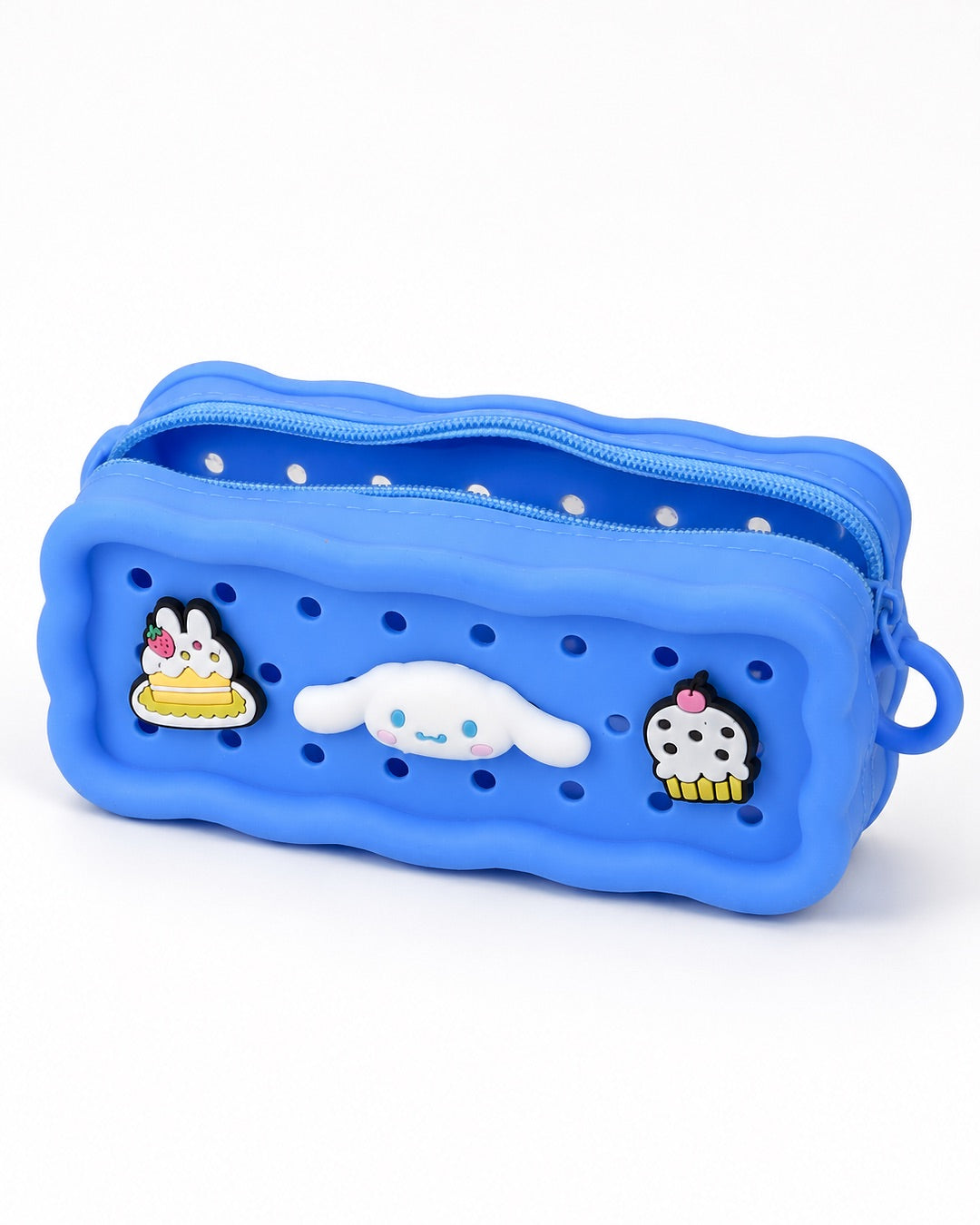 Trousse rectangulaire en silicone bleu avec des perforations contenant trois pins amovibles du personnage Cinnamoroll et de desserts.