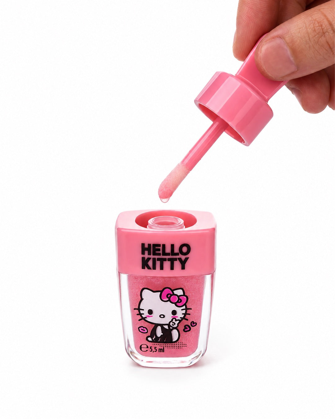Flacon de brillant à lèvres Hello Kitty ouvert, montrant une main qui retire l’applicateur intégré de la base en forme de bâtonnet de glace rose.