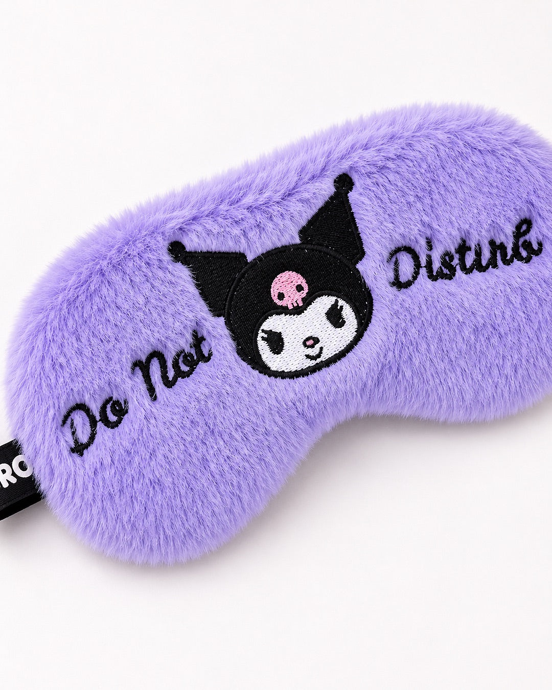 Vue rapprochée de biais d'un masque de sommeil en peluche violette Kuromi mettant en valeur la douceur du tissu et les broderies.