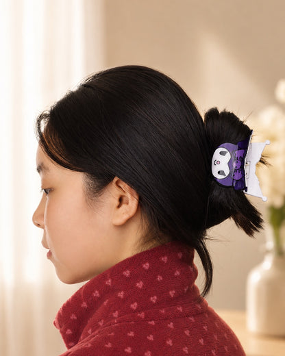 Profil d'une femme portant la petite pince à cheveux crabe à la forme de tête de Kuromi violette et noire de Sanrio pour attacher ses cheveux.