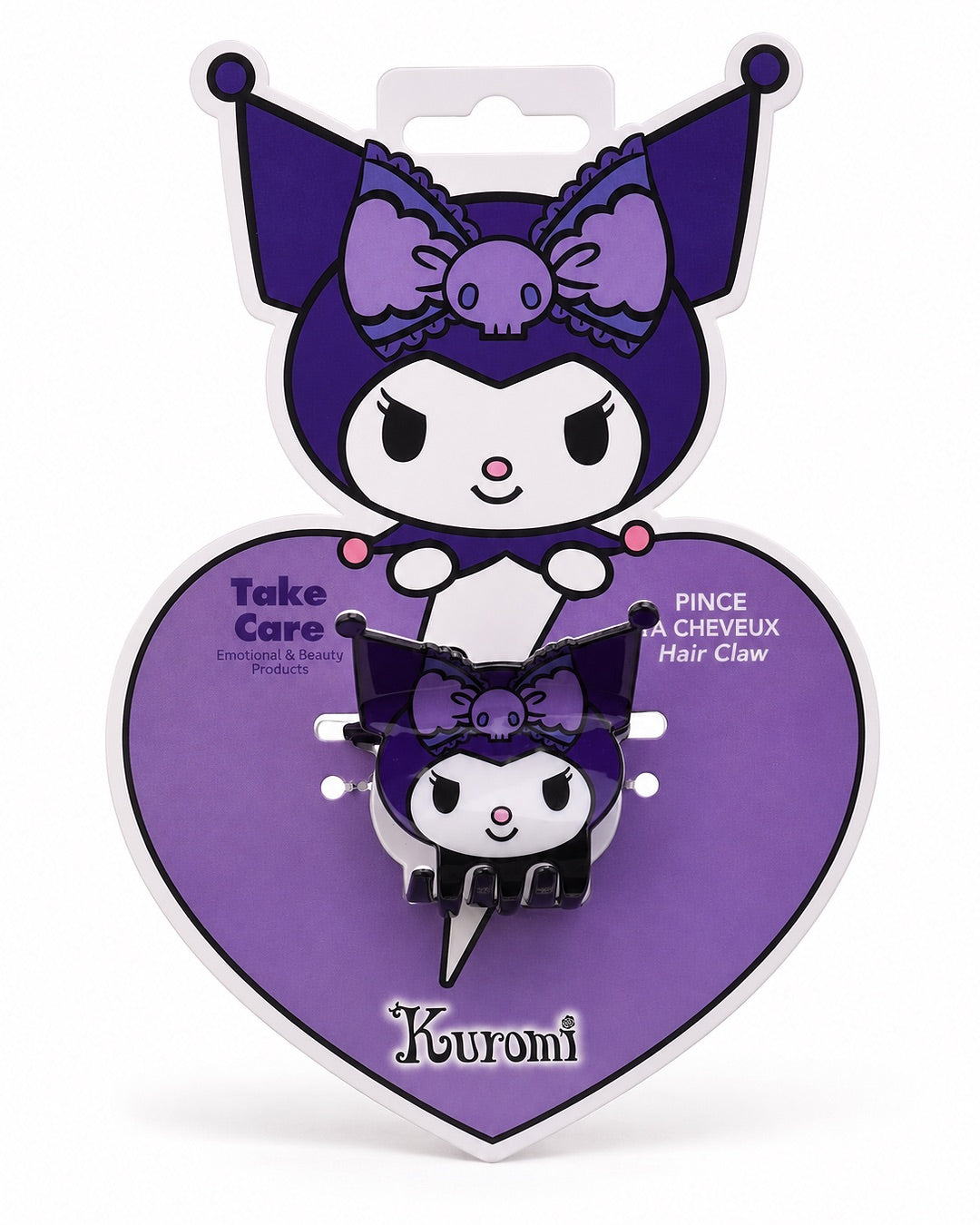 Vue de face de la pince à cheveux compacte noire et mauve en forme de tête et silhouette de Kuromi Sanrio dans son emballage cartonné en forme de coeur violet et la tête de Kuromi.
