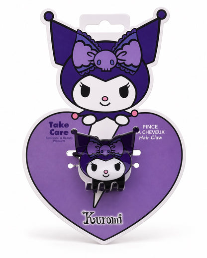 Vue de face de la pince à cheveux compacte noire et mauve en forme de tête et silhouette de Kuromi Sanrio dans son emballage cartonné en forme de coeur violet et la tête de Kuromi.