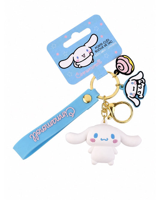 Porte-clés 3D Cinnamoroll avec lanière en silicone bleu, mousqueton doré, breloque de beigne rose et emballage cartonné bleu d'origine.