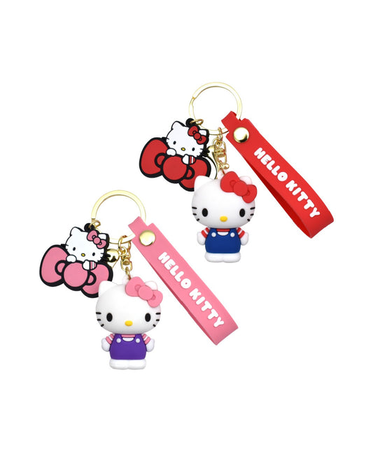 Vue de face de deux porte-clés figurines 3D Hello Kitty de la collection Sanrio : le modèle du haut en version rouge classique avec salopette bleue et le modèle du bas en version rose poudré avec salopette violette.