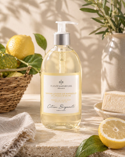 Une bouteille pompe de 500 ml de savon de Marseille liquide, fragrance Citron bergamote, Plantes & Parfums, dans son ambiance olfactive.