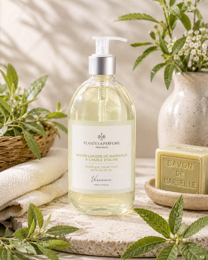 Une bouteille pompe de 500 ml de savon de Marseille liquide, fragrance Verveine, Plantes & Parfums, dans son ambiance olfactive.