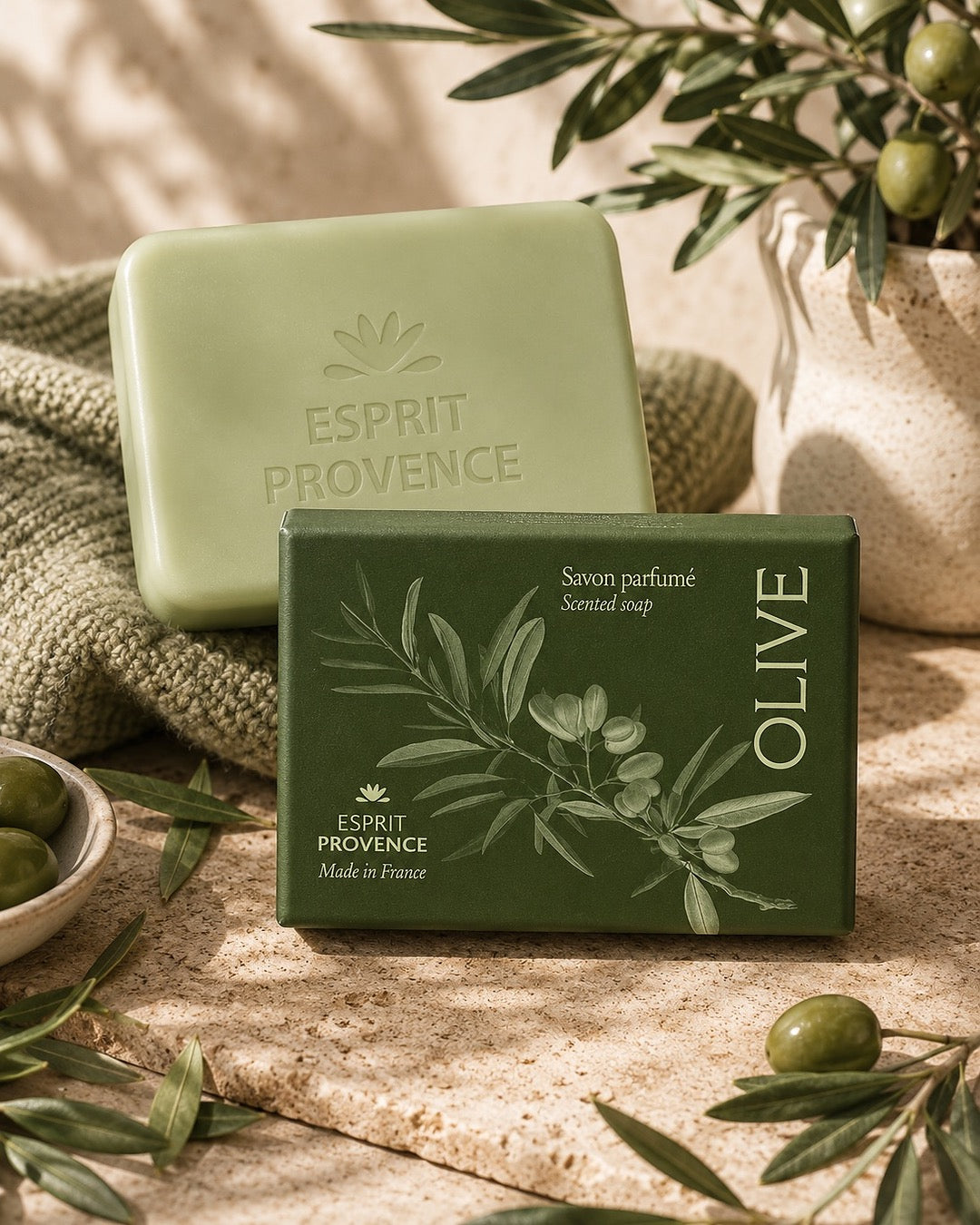 Savon en barre aux Fleurs d’Olivier 140 g, enrichi en beurre de karité bio. Signé Esprit Provence. Dans son emballage papier et son ambiance olfactive.
