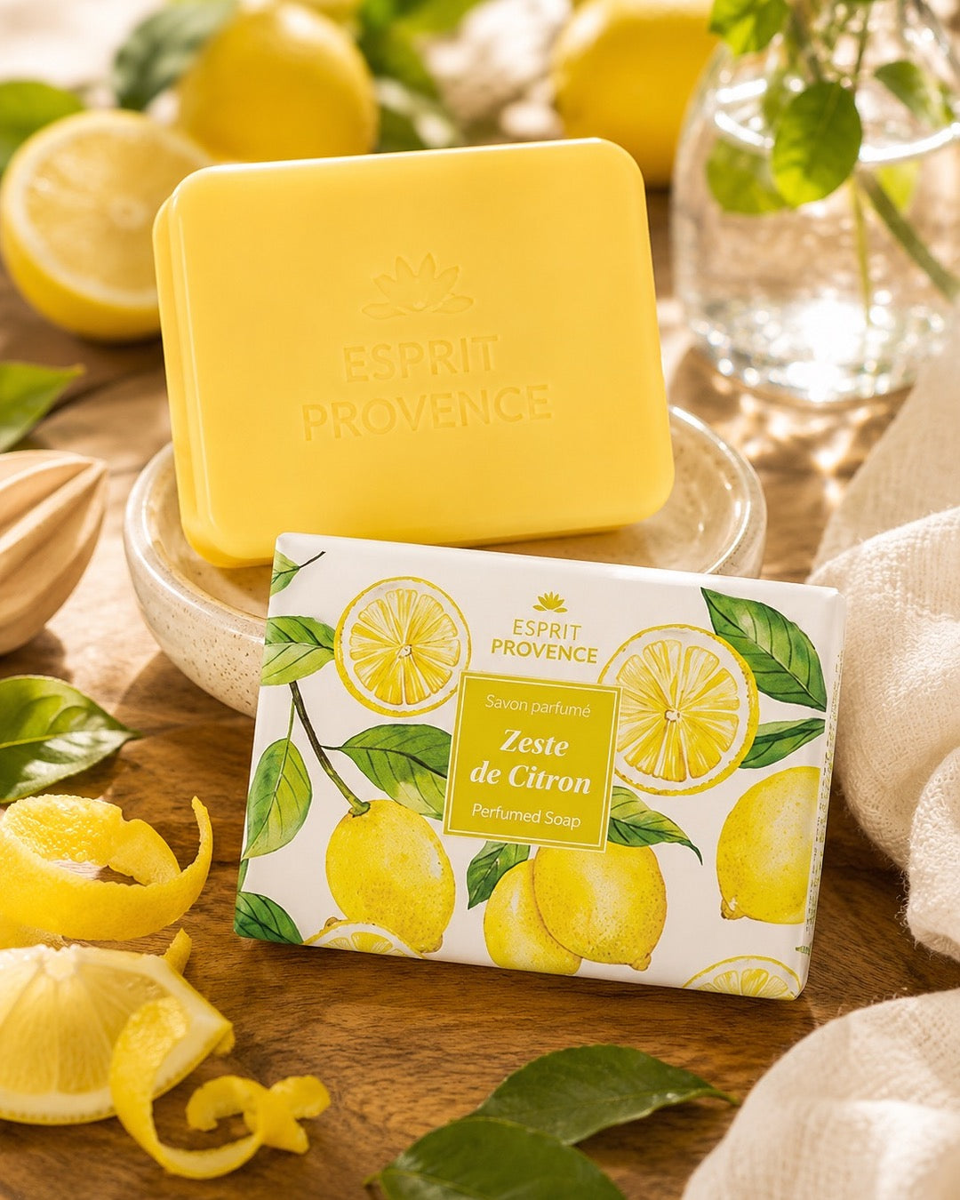 Savon à l’huile d’Amande douce de Provence 140 g, au parfum de Zeste de Citron, signé Esprit Provence et enrichi en beurre de karité BIO. Dans son emballage papier et son ambiance olfactive.