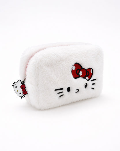 Vue de trois quarts d’une trousse à maquillage rectangulaire en peluche blanche Hello Kitty, brodée avec le visage de la mascotte et son nœud rouge.