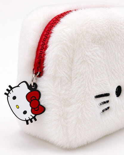 Gros plan détaillé sur la fermeture éclair rouge de la trousse en peluche blanche, mettant en valeur le curseur en forme de figurine Hello Kitty souple.