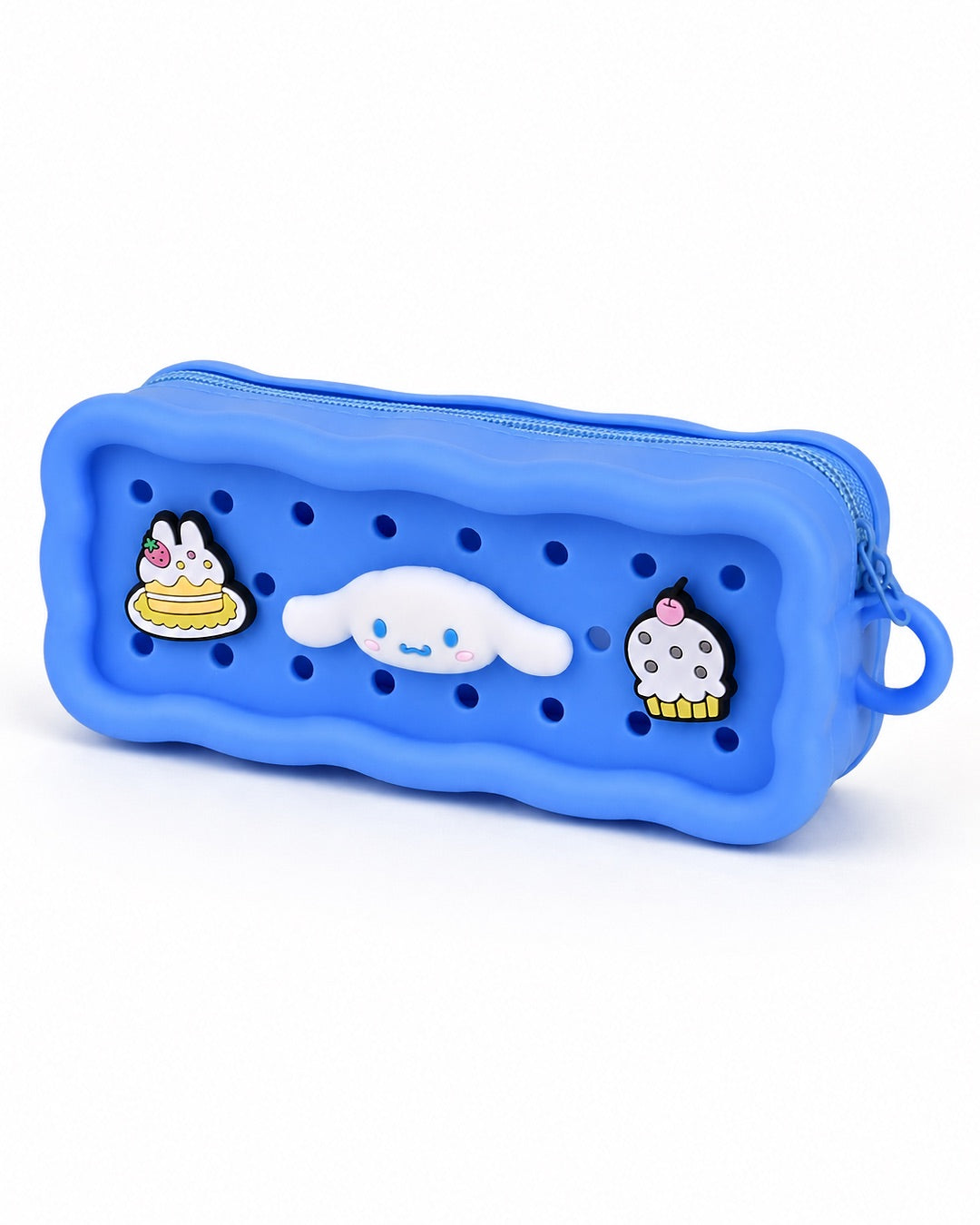 Trousse rectangulaire en silicone bleu avec des perforations contenant trois pins amovibles du personnage Cinnamoroll et de desserts.